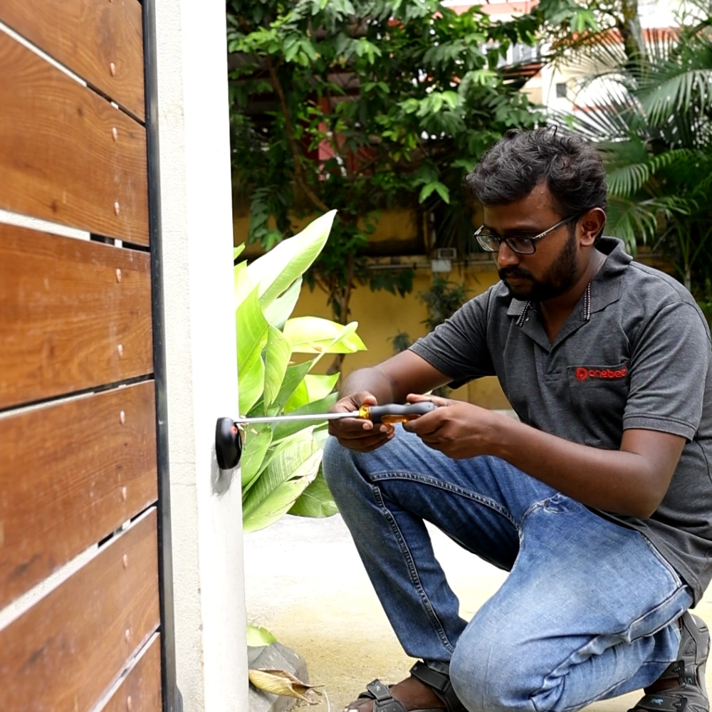 OneBee technician installing gate automation sensors and motor for improved building security.